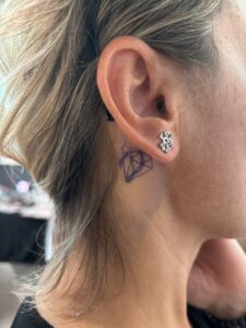 Tatuaggio copertura piccolo diamante dietro l'orecchio Umbria Acca Elena Ink