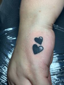 Tatuaggio copertura due cuori piccoli sul polso Umbria Acca Elena Ink