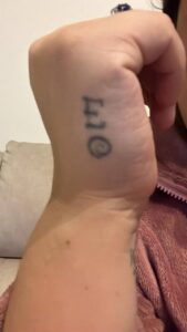 Vecchio tatuaggio EO sulla mano prima della copertura Umbria Acca Elena Ink