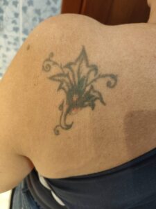 Foto prima della copertura di un vecchio fiore sbiadito sulla spalla Umbria Acca Elena Ink